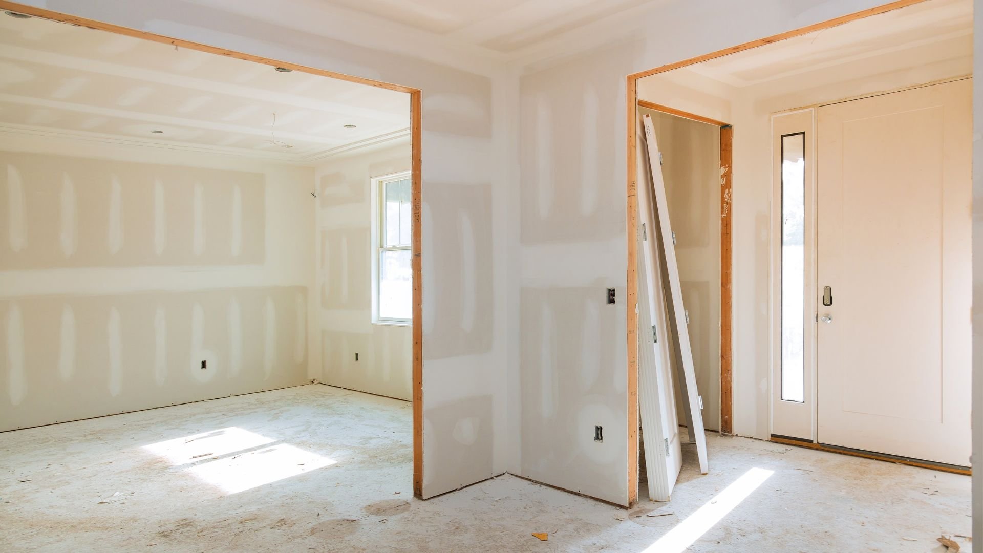 Interior room with drywall, wooden door frames, and construction materials