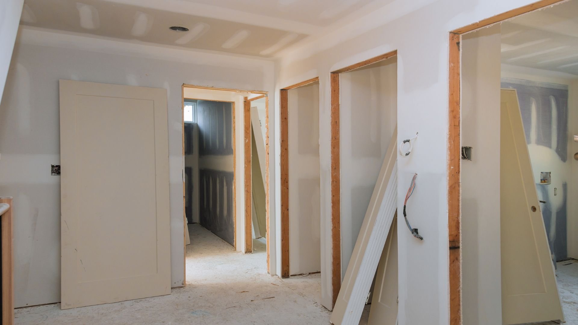 Interior home renovation with unfinished walls, doors, and electrical outlets